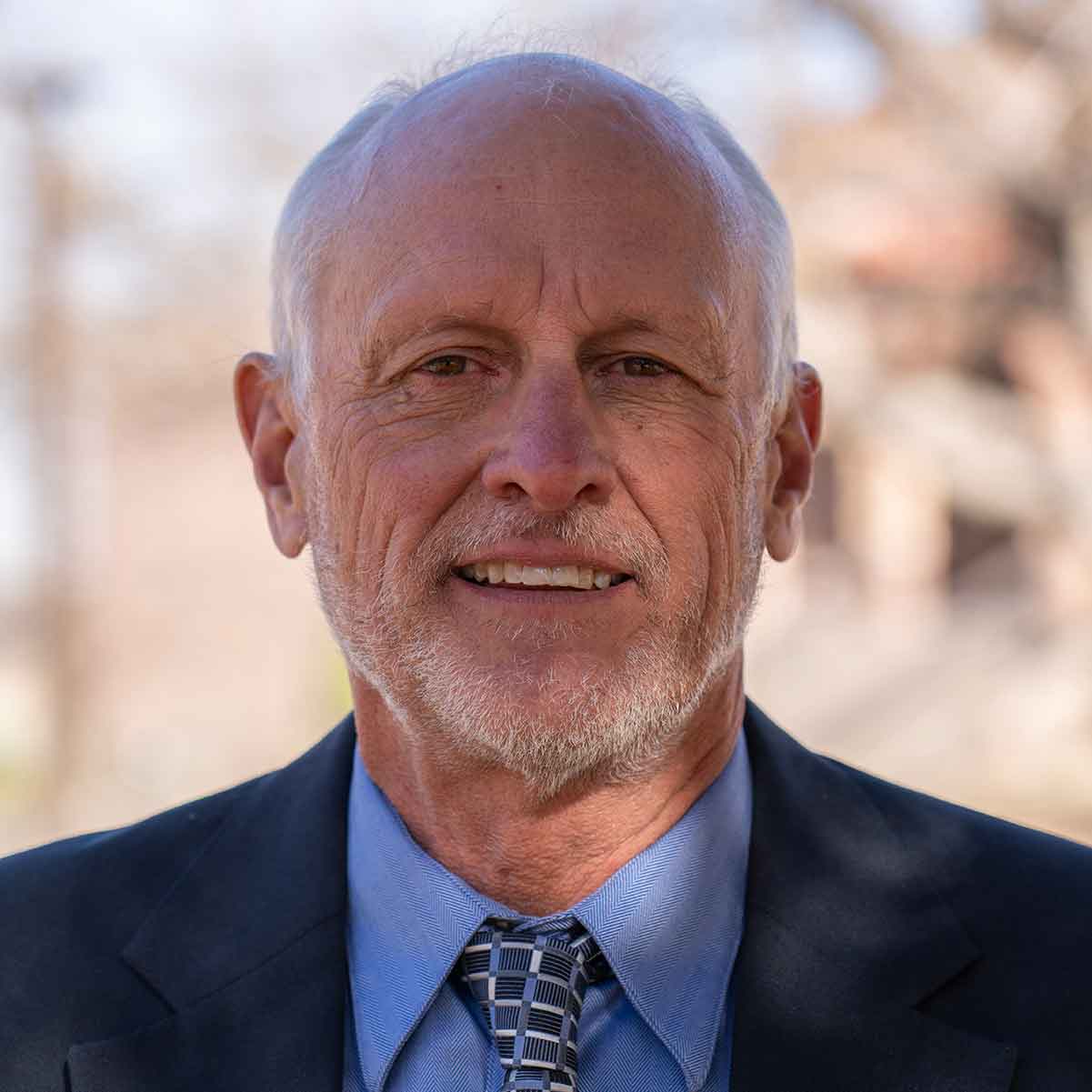 Headshot portrait of Kevin Urbanczyk, Ph.D. standing outdoors.
