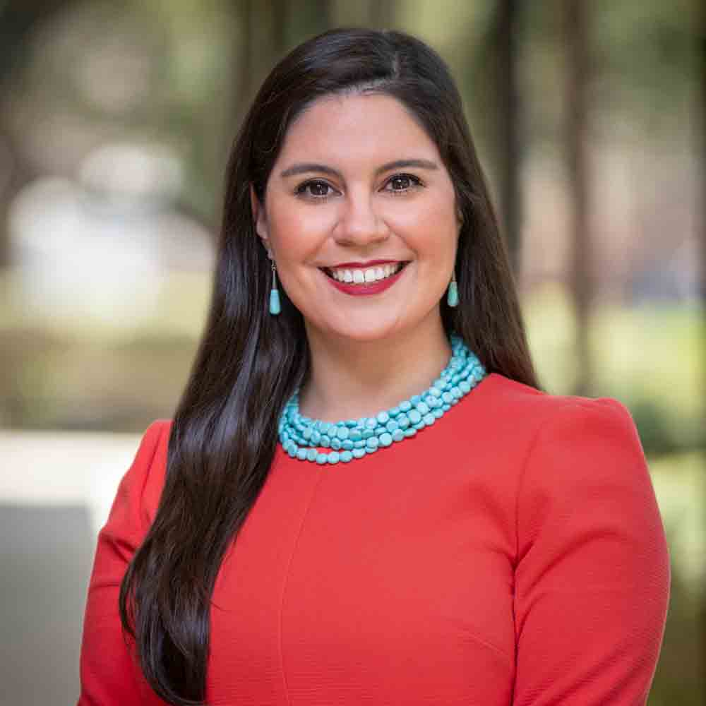 Lizette Villarrea smiling and standing outdoors.